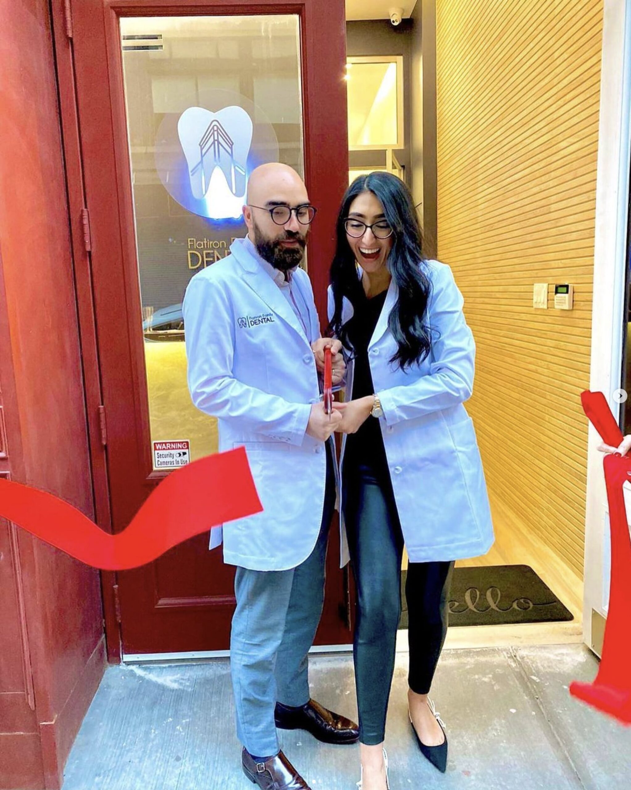 about-us-flatiron-family-dental-doctors-cutting-red-ribbon